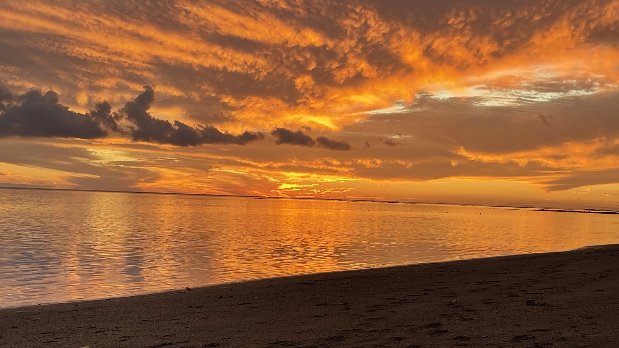 Golden-hour sunset over the calm waters of Molokaʻi's south shore, Hawaiʻi